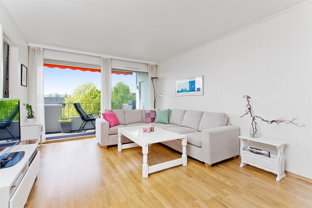 Stue med store lysflater og skyvedør mot veranda Galleribilde