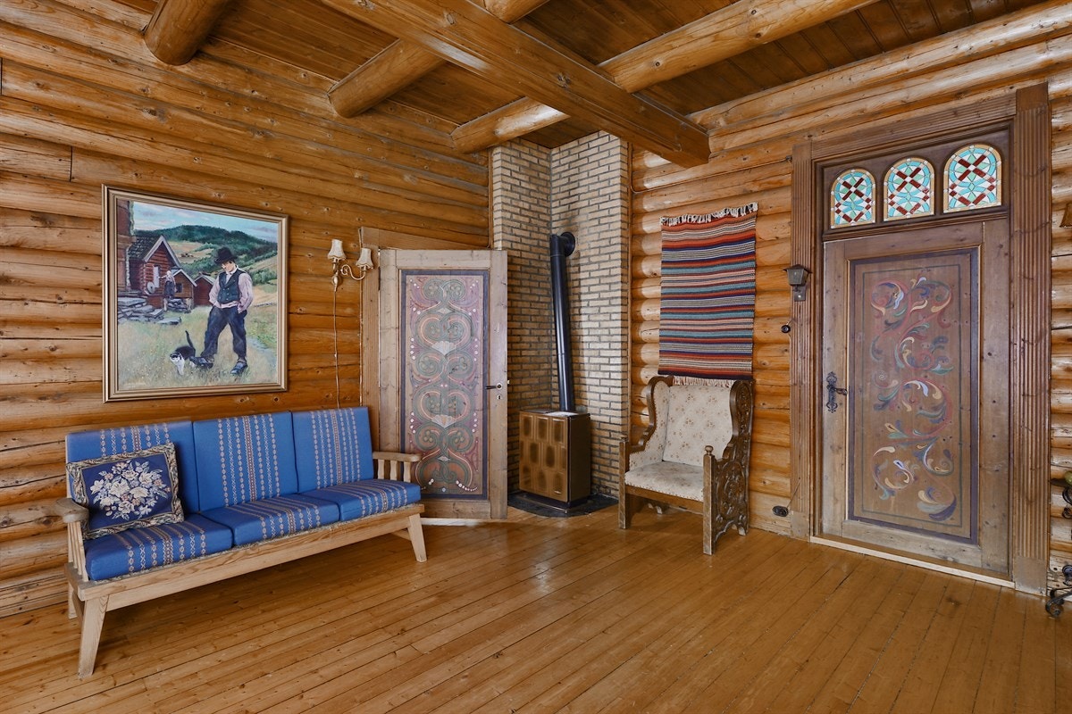 Spisestue/peisestue i 1.etg med parafinovn. Over døren mellom peisestuen og stuen i 1.etg. er det blyvinduer i kirkestil med vakker farvevirkning forarbeidet av glassmester Larsen i Christiania. Galleribilde