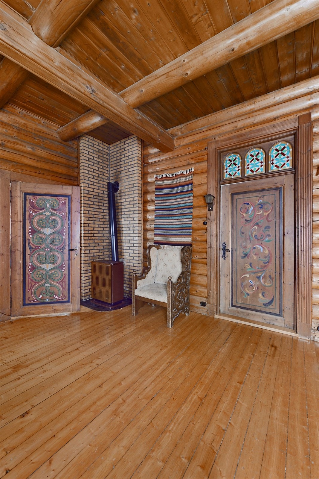 Spisestue/peisestue i 1.etg med parafinovn. Over døren mellom peisestuen og stuen i 1.etg. er det blyvinduer i kirkestil med vakker farvevirkning forarbeidet av glassmester Larsen i Christiania. Galleribilde