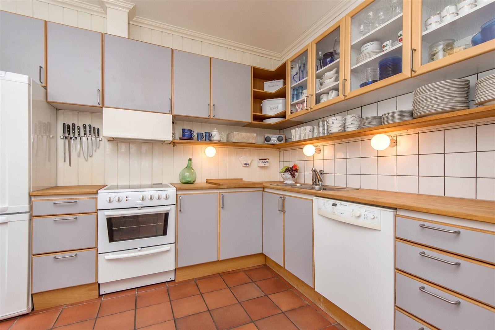 Kjøkkeninnredning med glatte grå fronter og heltre kjøkkenbenk. Galleribilde