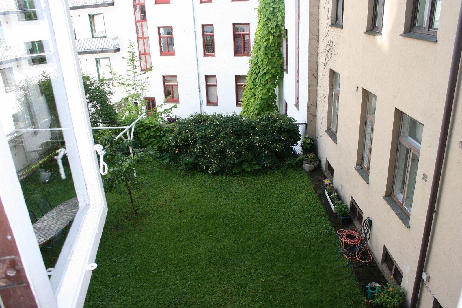 Grønn og frodig bakgård med felles spisebord Galleribilde