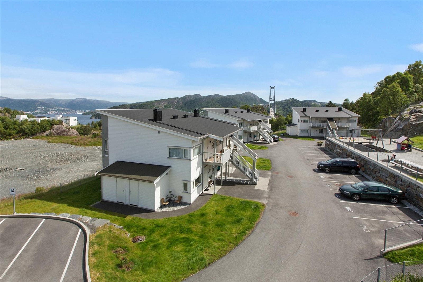Leiligheten har faste parkeringsplasser på framsiden av boligen i tillegg til gjesteparkering på venstre side. Galleribilde