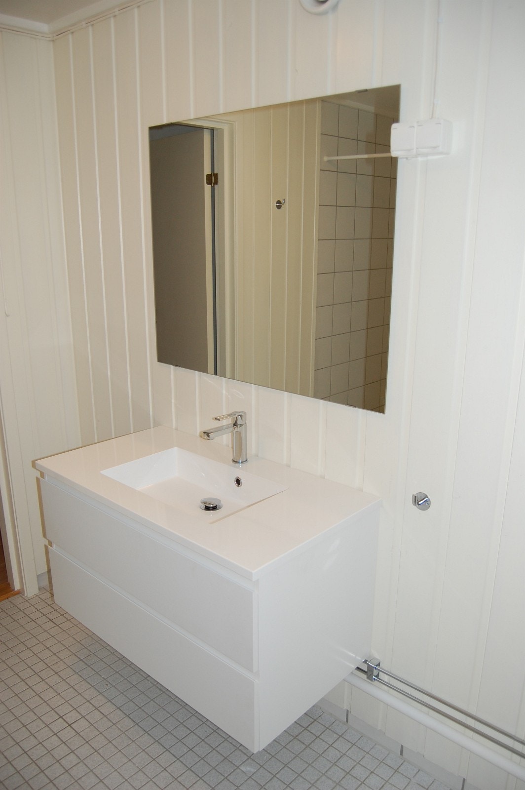 Bad med varmkabler i gulv, wc, dusjnisje, servant med skuffer under. Vaskemaskin er i leiligheten. Galleribilde