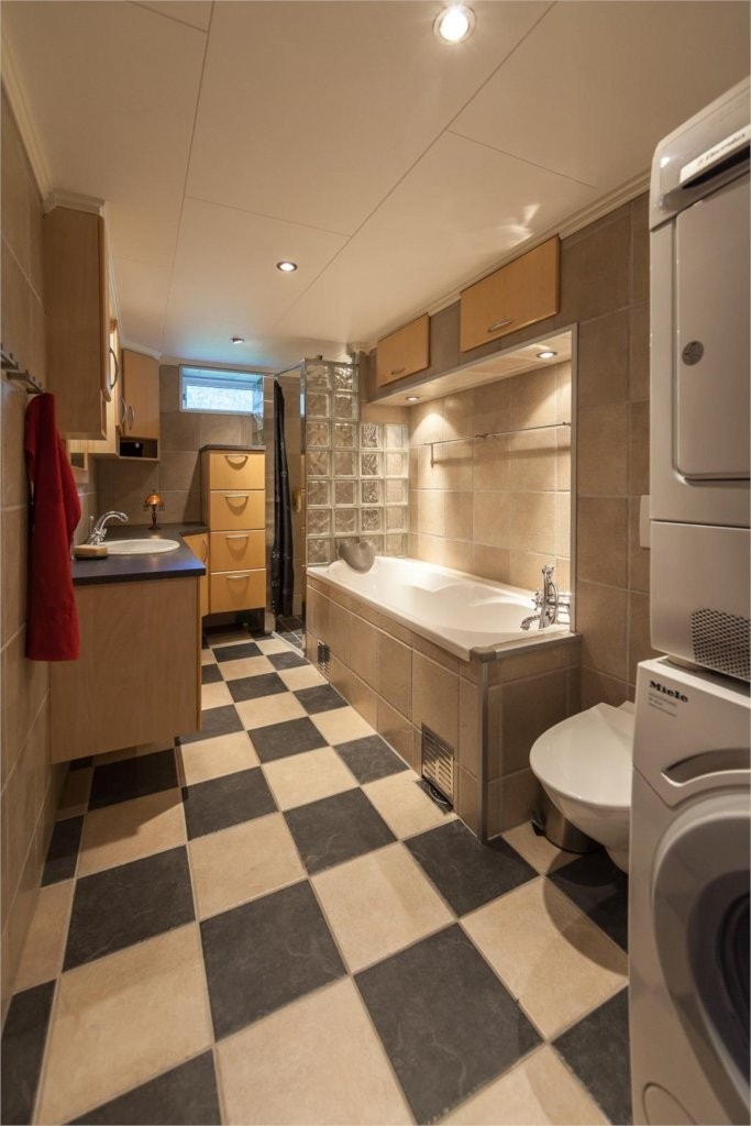 Bad og vakserom i 1. etasje / sokkeletasjen. Flislagt gulv og vegger Galleribilde