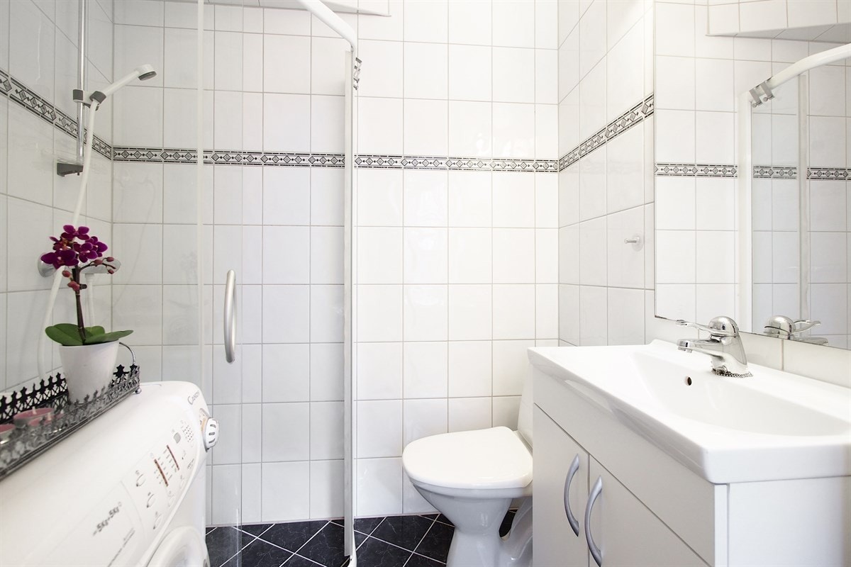 Badet er delikat og tiltalende med en pen kombinasjon av mørke og lyse fliser. Galleribilde