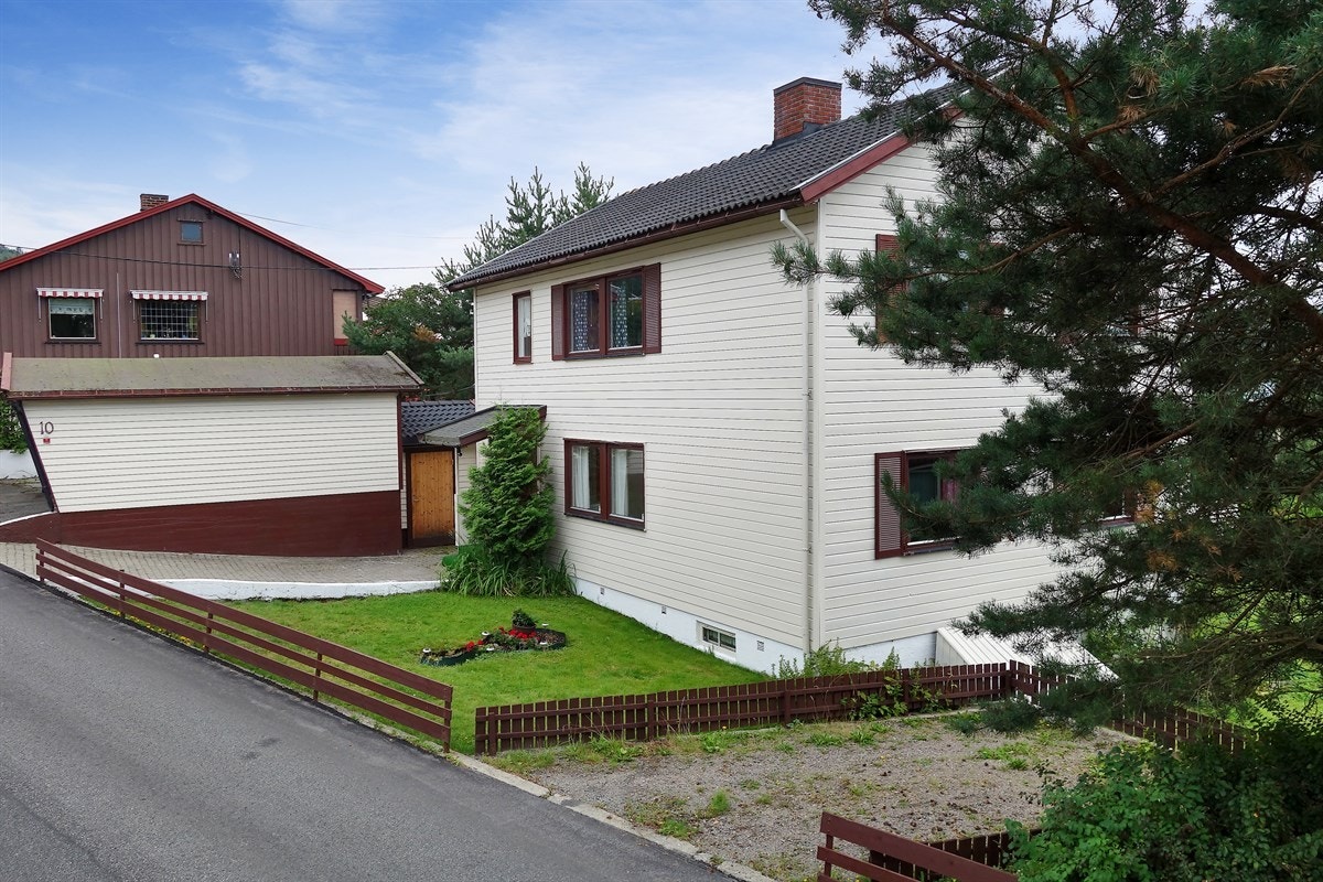 Fasade, garasje og biloppstillingsplasser på tomten. Galleribilde