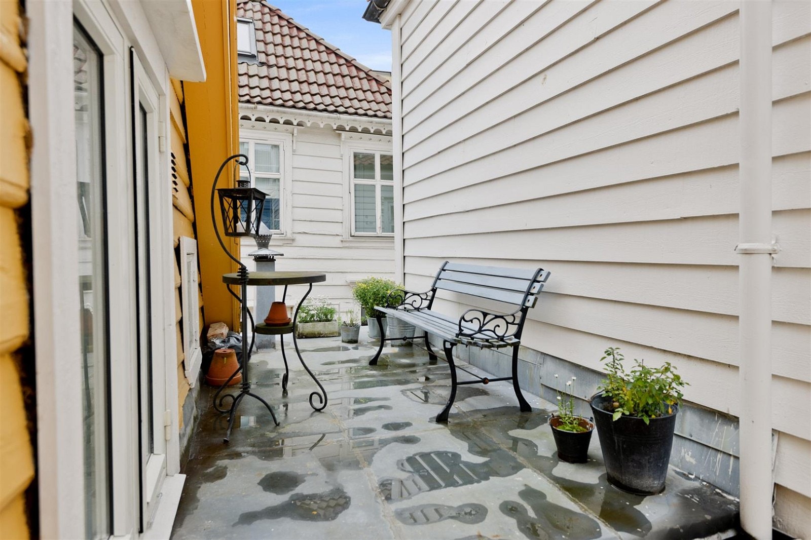 Den lille og borgjemte "uteplassen" mellom husene. Uteplassen er et flatt tak (tekket med sink) som går over badet i 1. etasje. Galleribilde