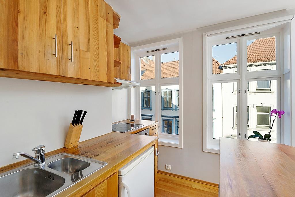 Kjøkken med med plassbygd innredning, integrert komfyr og koketopp. Galleribilde