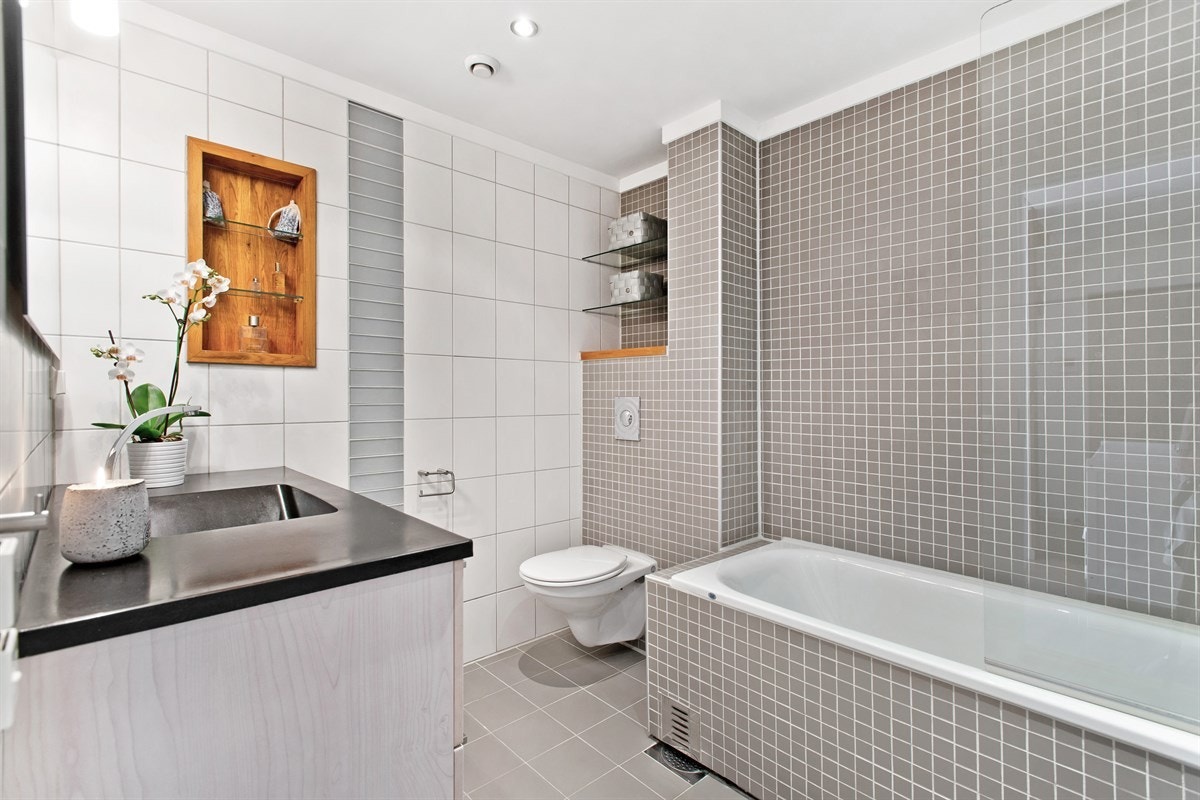 Delikat, flislagt bad med tidsriktig design og flotte detaljer Galleribilde