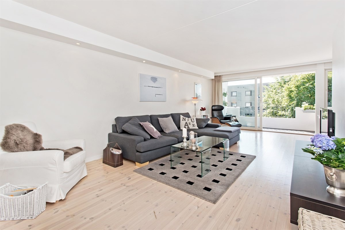 Lys stue med store vindusflater og spotkasse i tak Galleribilde