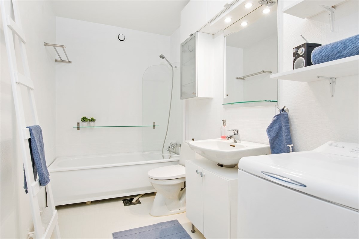 Badet har en god størrelse med lys innredning og badekar med glassvegg Galleribilde