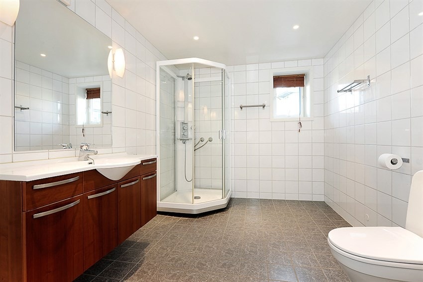 Lekkert bad med fliser på gulv og vegger Galleribilde