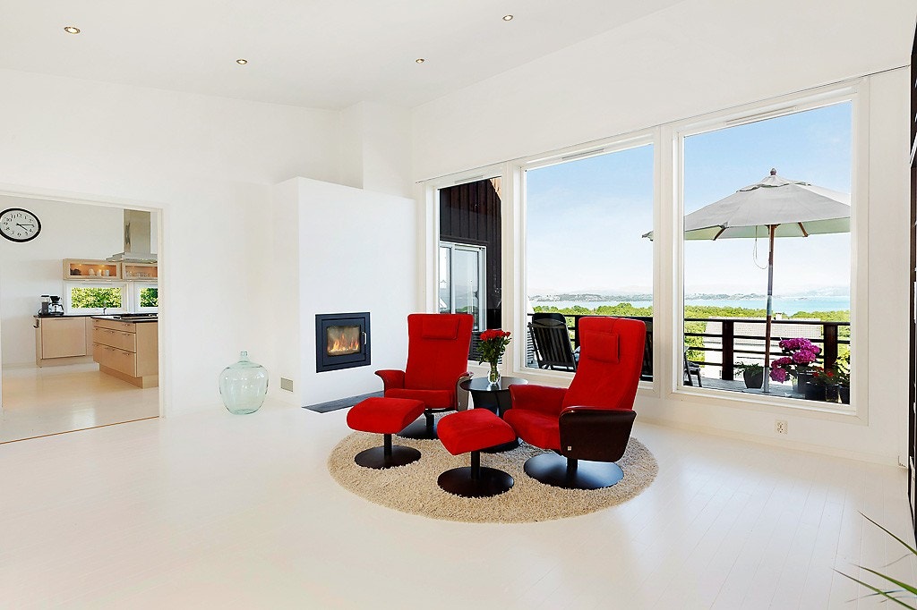 Stuen med kjøkkenet i bakgrunnen. Legg merke til den fine peisen. Galleribilde