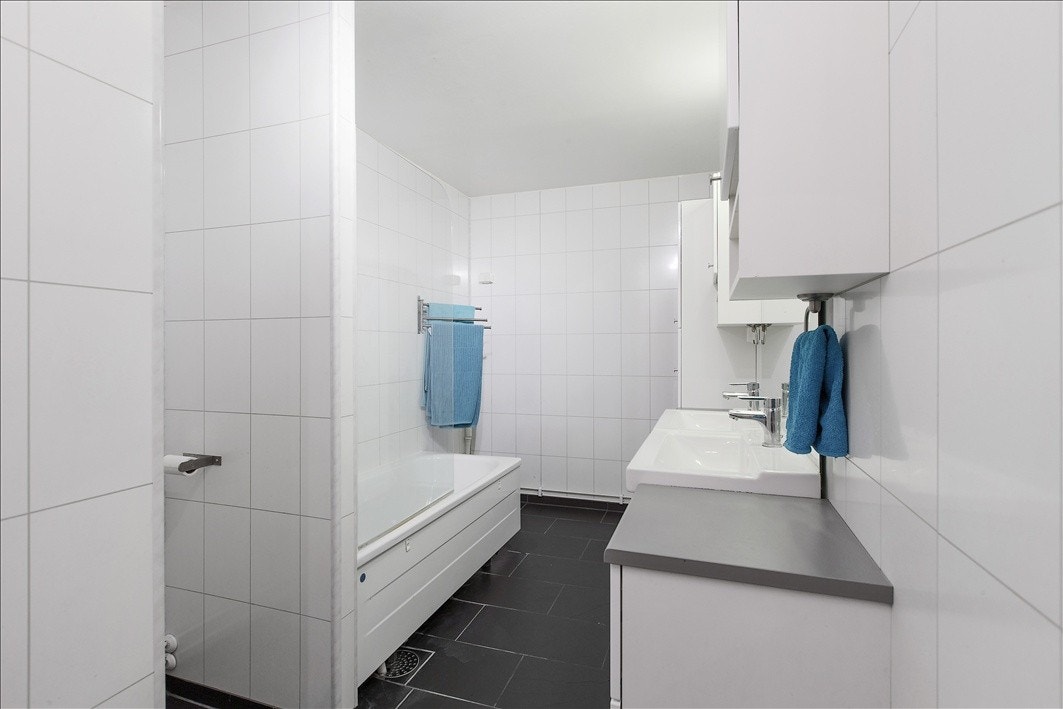 Pent flislagt bad med varmekabler, dobbel servant, wc og badekar Galleribilde