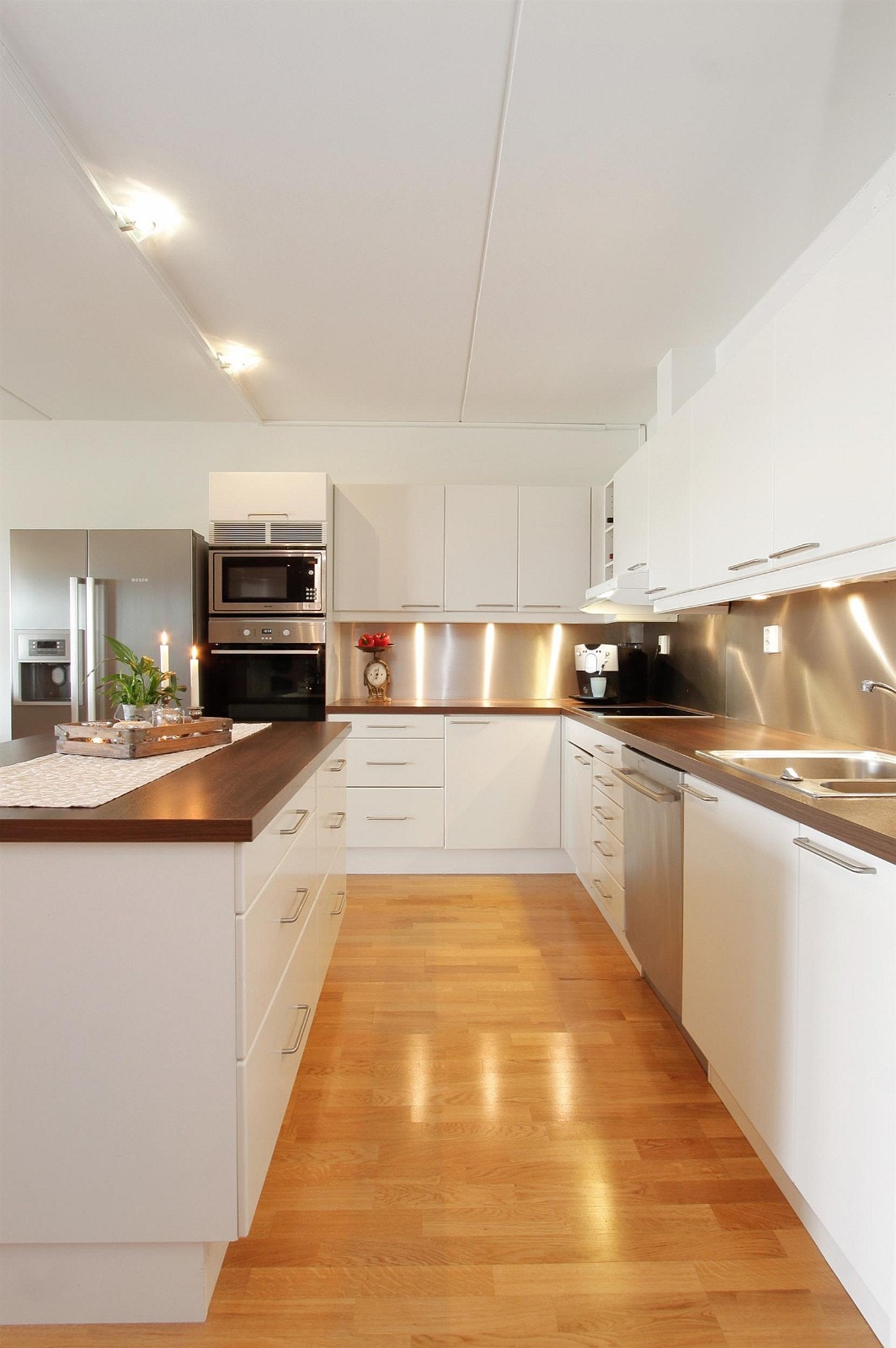 Kjøkkenet har integrert stekeovn, indusksjonsplatetopp, microbølgeovn og oppvaskmaskin Galleribilde