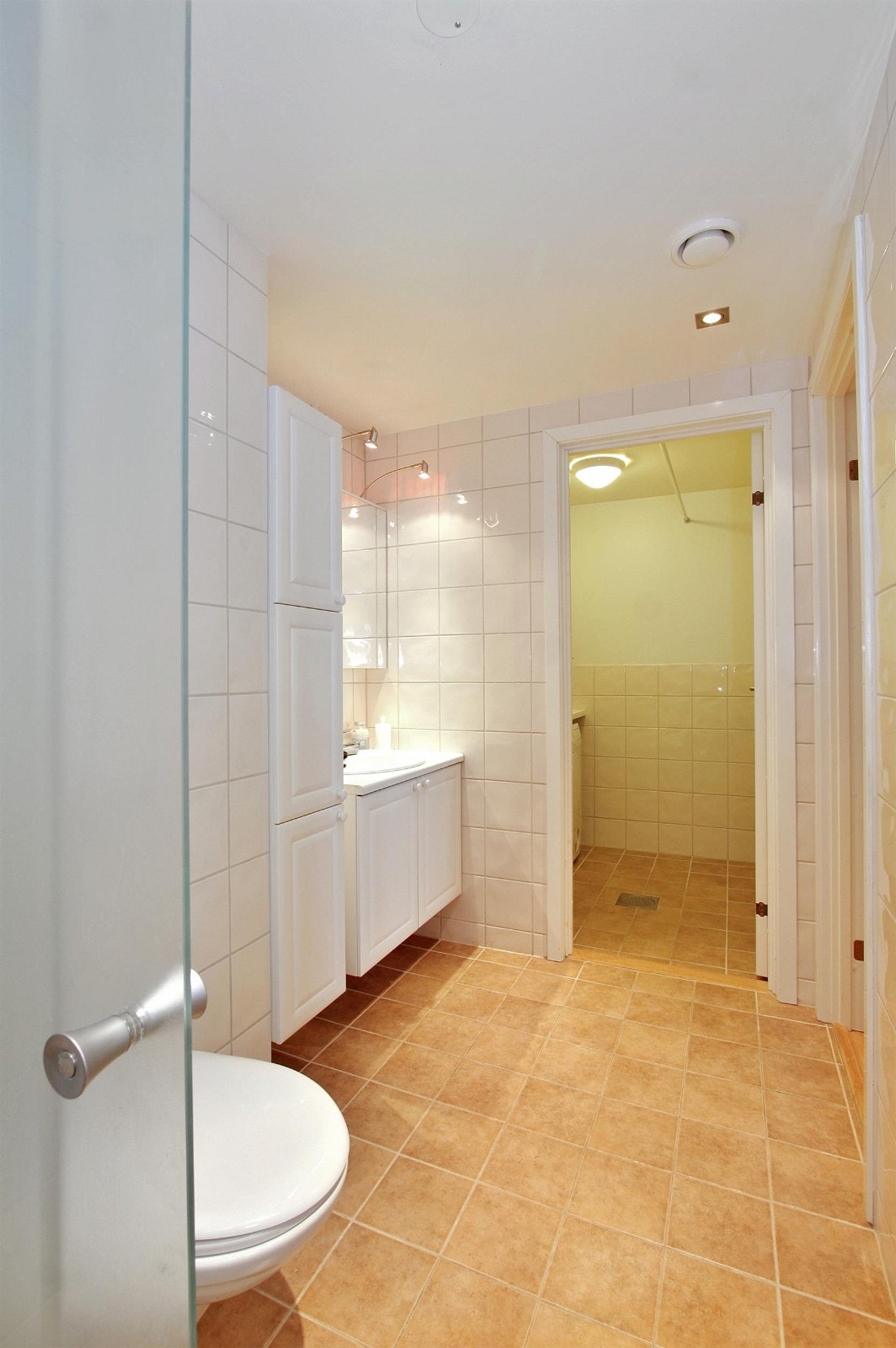 Pent, flislagt bad med dør til vaskerom Galleribilde