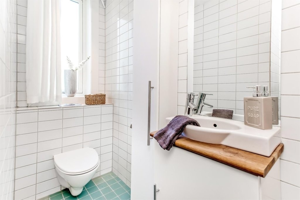 Leiligheten har et moderne romslig og flott flislagt bad/wc med vindu. Det er rikelig med skapplass på det fine badet Galleribilde