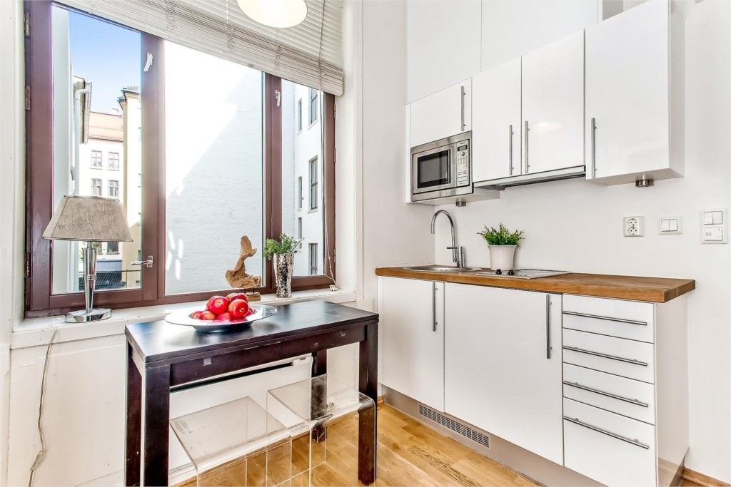 Kjøkkenet har benkekjøleskap, micro med stekefunksjon og nedfelt koketopp Galleribilde