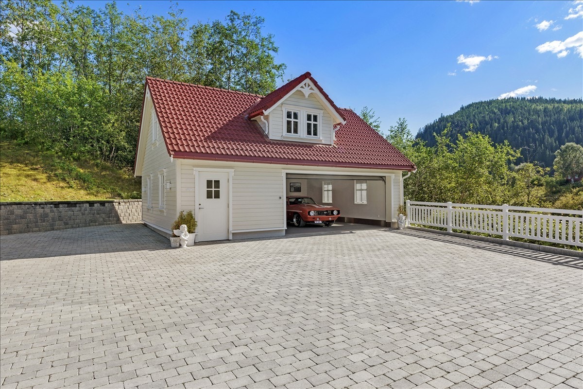 Garasjen nærmest boligen er langt fra tradisjonell: Med flislagt gulv, kjøkkenkrok og med fullt innredet loft så er dette selve Nirvana for hobbymekanikeren! Galleribilde