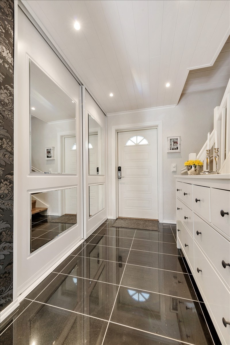 Entrèen har høyglanspolert granittflis på gulv og stor skyvedørsgarderobe. Galleribilde