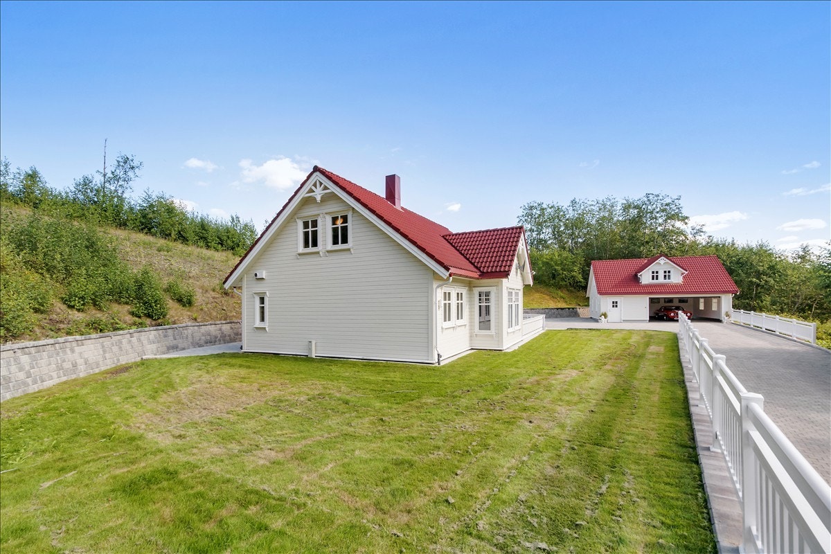 Utenfor bolighuset er tomta opparbeidet med forstøtningsmur slik at plenområdet er flatt og brukervennlig. Galleribilde