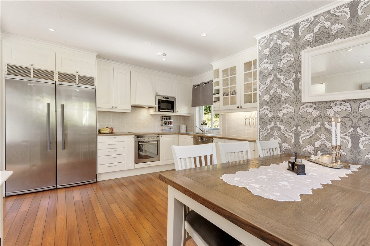 Tradisjonelt og tidløs kjøkken i landlig stil. Integrerte hvitevarer. Galleribilde