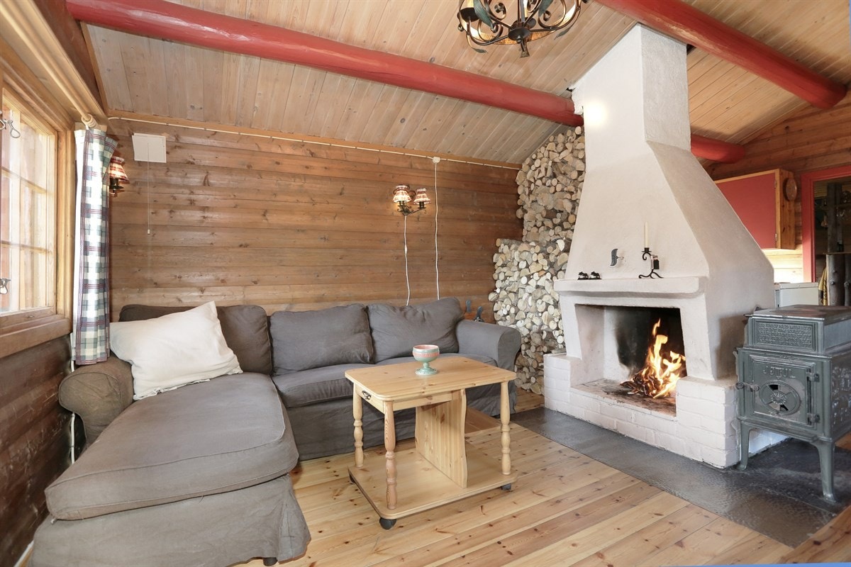 Hytta har ei koselig stue med flott, hvitmalt peis. Galleribilde