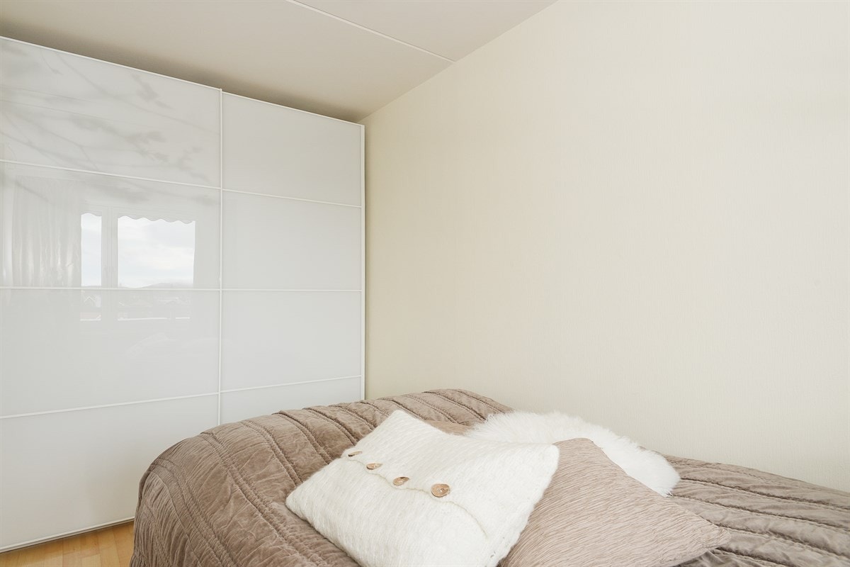 Leiligheten har et pent soverom med nyere skyvedørsgarderobe med hvite glassfronter. Garderoben er innholdsrik og har mye tilbehør for smykkeoppbevaring m.m. Galleribilde