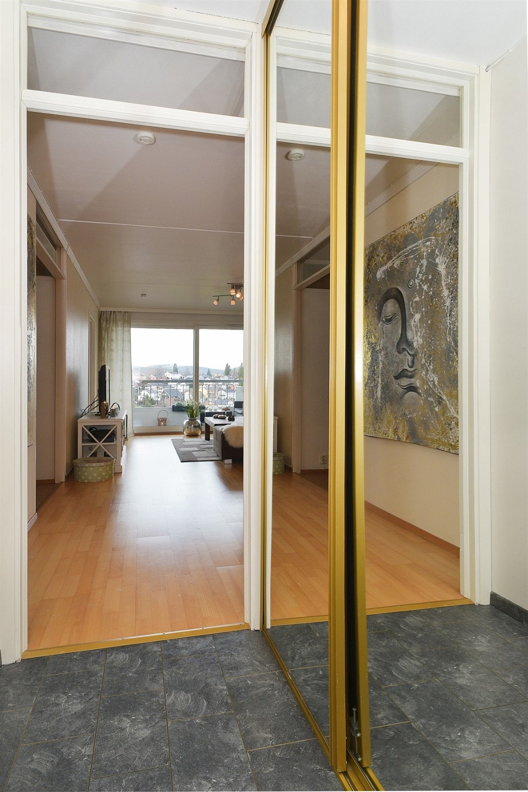 praktisk innredet entré med flislaminat, åpen garderobeløsning og skyvedørsgarderobe med speilfronter. Galleribilde