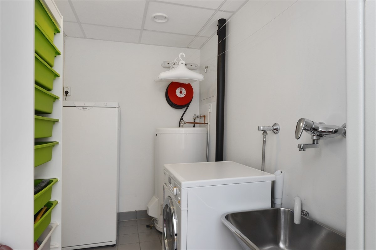 Eget vaske/tørkerom med fliser på gulv og gulvvarme. Galleribilde