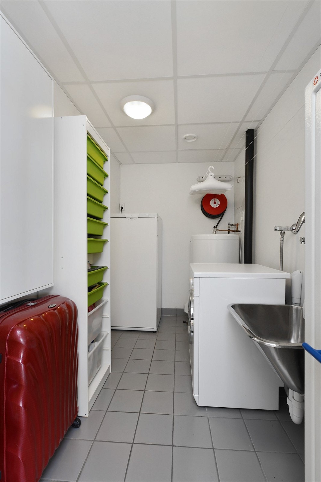 Eget vaske/tørkerom med fliser på gulv og gulvvarme. Galleribilde