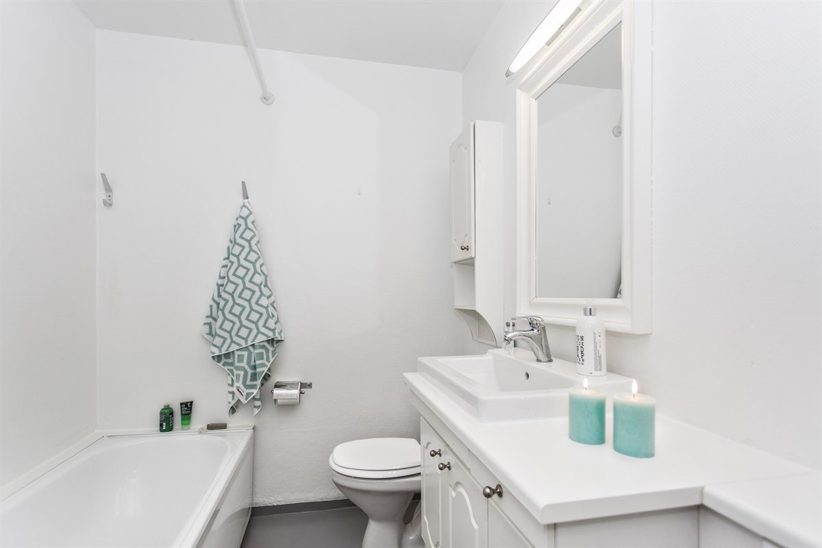 Romslig bad med badekar og opplegg for vaskemaskin Galleribilde