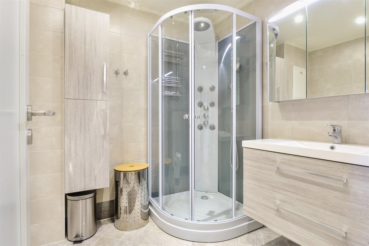 Nyere og meget pent flislagt baderom. Dusjkabinett. Varme i gulv. Downlights i himling. Flott innredning. Veggmontert klosett. Opplegg vaskemaskin og trommel. Galleribilde