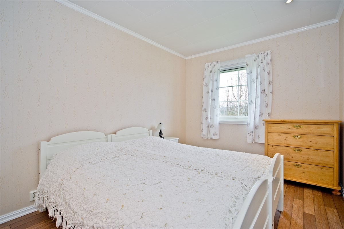 Hovedsoverom med lyse vegger og laminatgulv. Galleribilde