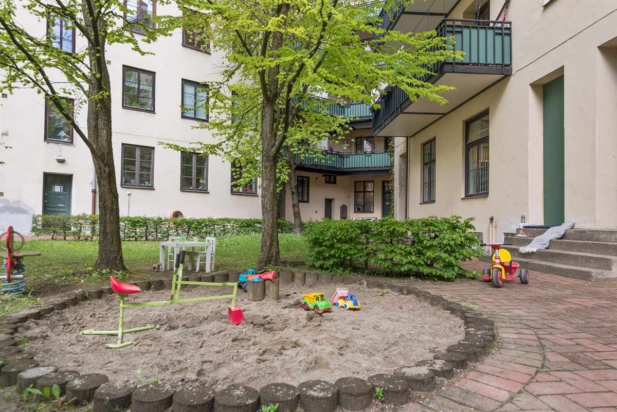 Pent opparbeidet bakgård med belegningsstein, sykkelparkering, sittegrupper, lekeplass og diverse beplanting. Galleribilde