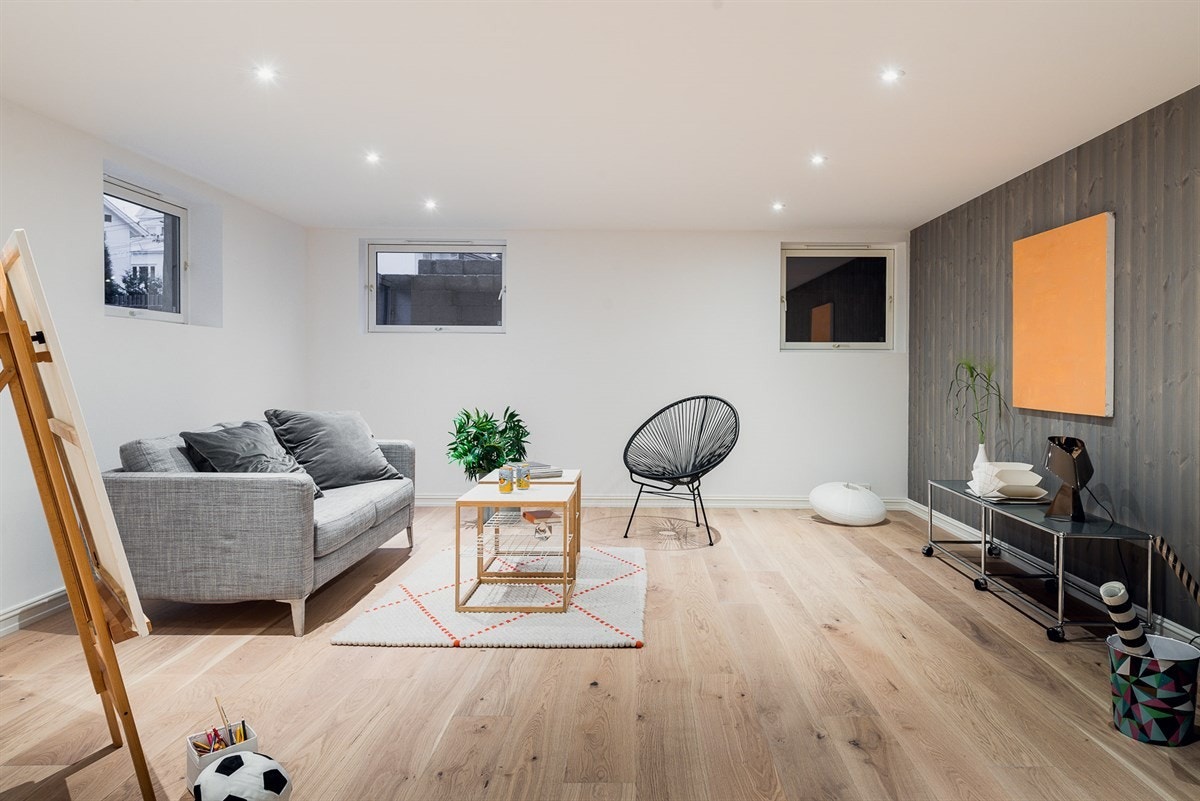 Underetasjen byr på ytterligere oppholdsplass for familien i en romslig kjellerstue, som utmerket gjerne både kan være en dedikert TV-stue, et hobbyrom eller til og med et treningsrom. Galleribilde