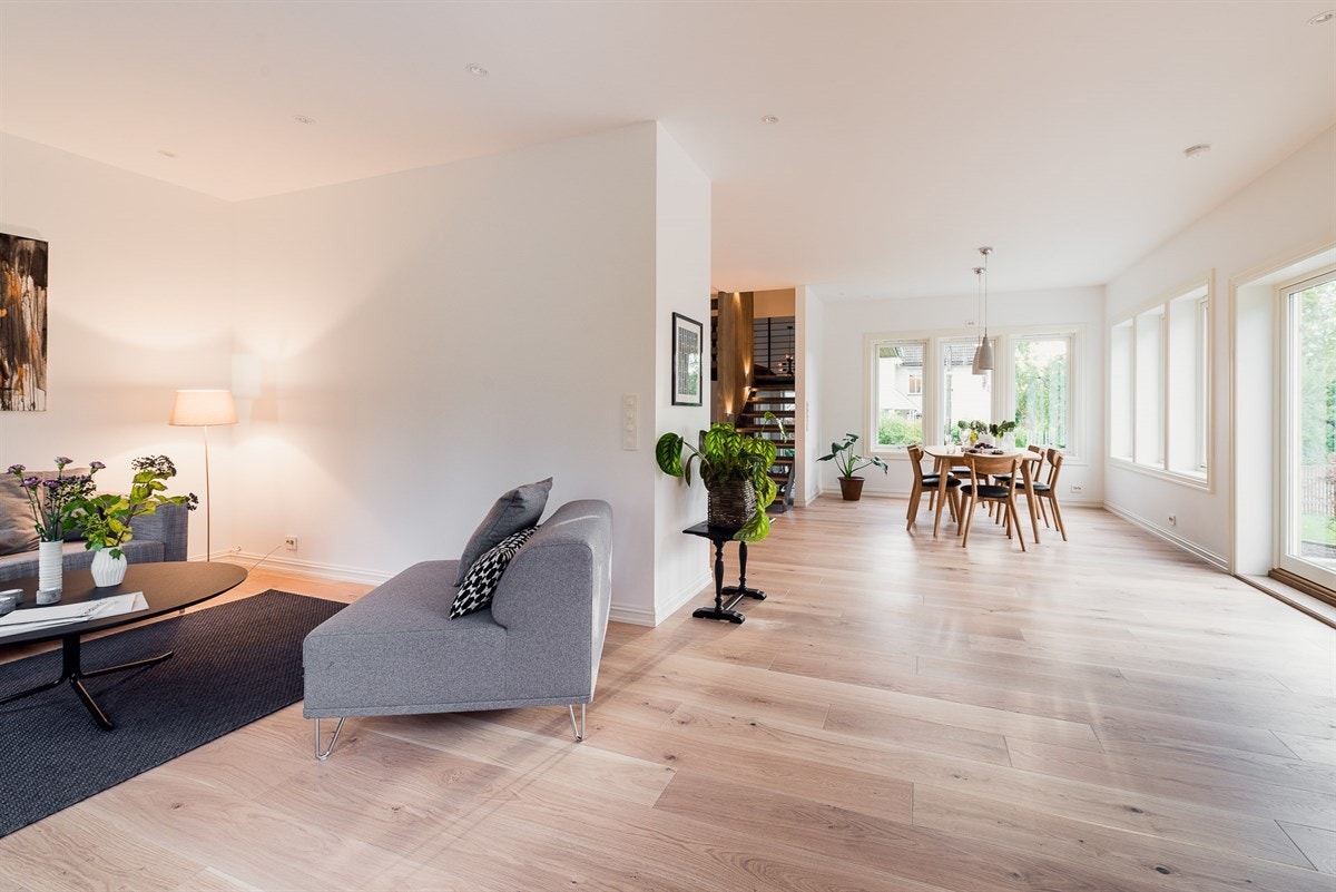 Kombinasjonen av en rekke vindusflater og hvitmalte overflater gir stuen et behagelig lyst preg. Galleribilde