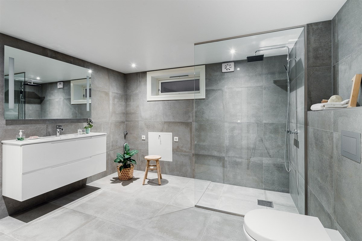 Vegg i vegg med kjellerstuen ligger bad nummer to - kombinert som et vaskerom og med rikelig manøvreringsplass Galleribilde