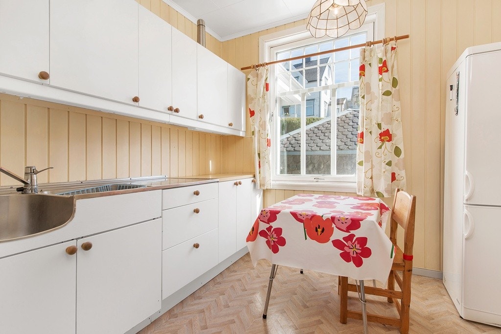 Kjøkken i 1. etg. er 9,5 kvm. og av eldre dato, men fortsatt funksjonabelt med masse lagringsplass i over-og underskap. Boenheten i 1 etasje har vært gjenstand for utleie i store deler av eiers botid med 3 hybler, felles kjøkken og bad. Galleribilde