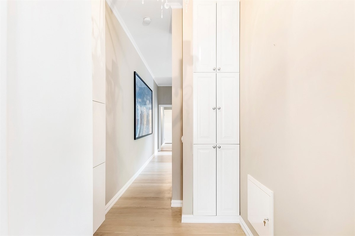 Gang med praktisk opplegg for vaskemaskin og tørketrommel i skapet. Galleribilde