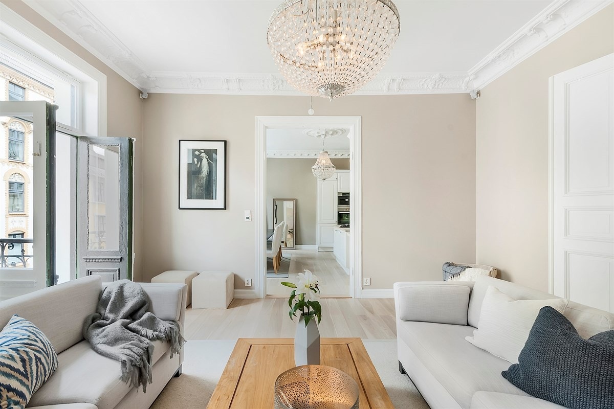 Leiligheten har en innbydende stue med åpen løsning mot spisekjøkkenet. Rommet har tofløyede dører, rabitzpussede himlinger, stukkatur og rosett, hvor selve kronjuvelen er en antikk kakkelovn Galleribilde