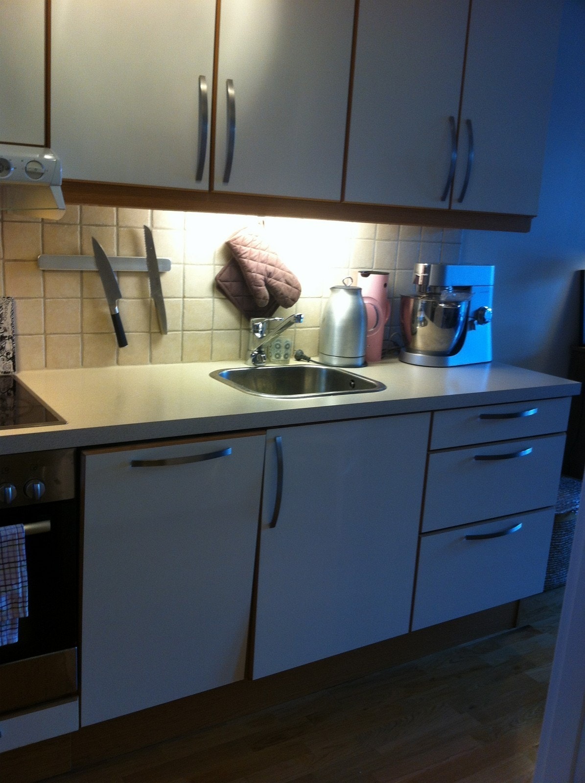 Lyst og pent kjøkken med lyse fronter og kjøkkenbenk. Galleribilde