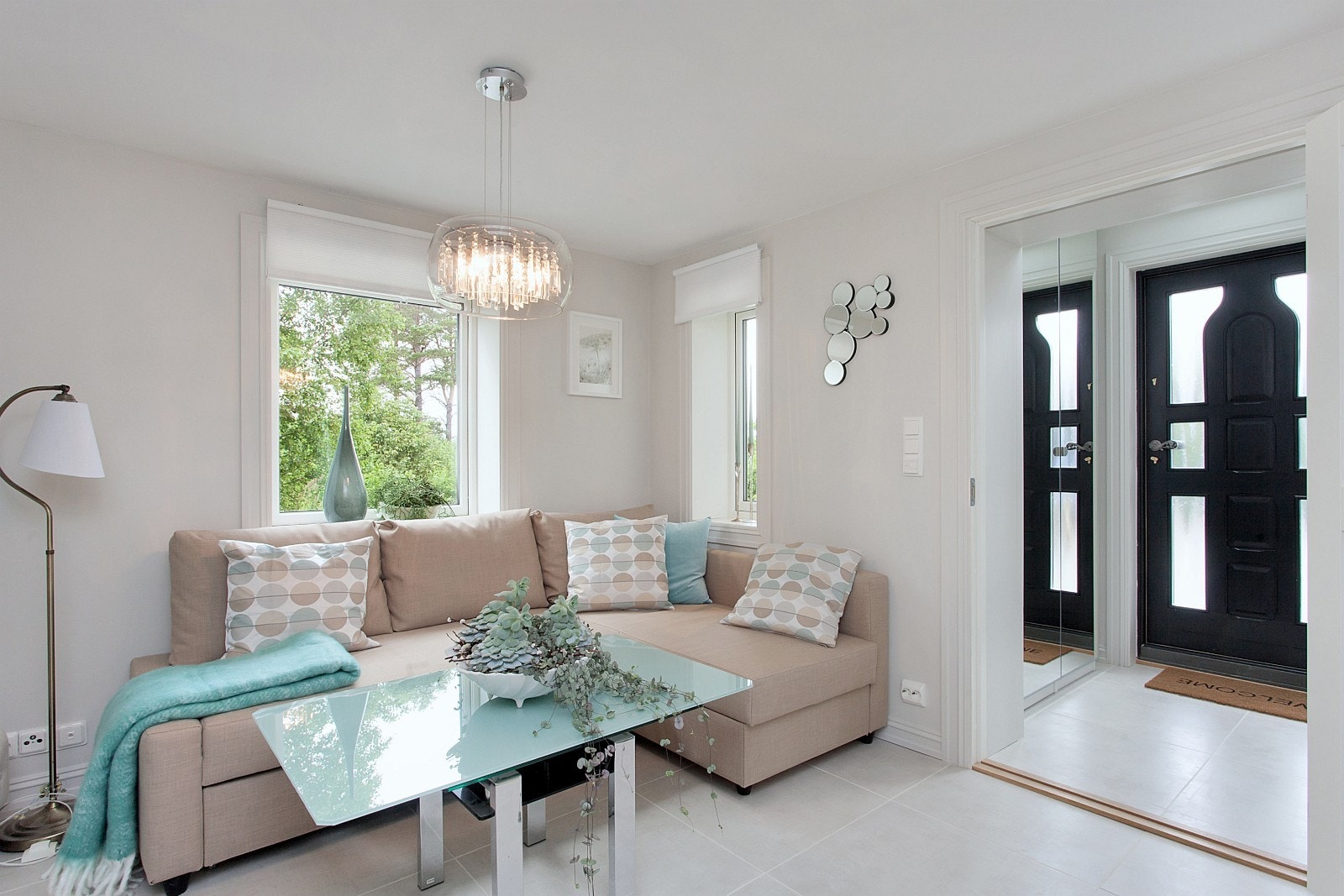 Stue med lun sofakrok og lysinnfall fra tre vinduer Galleribilde