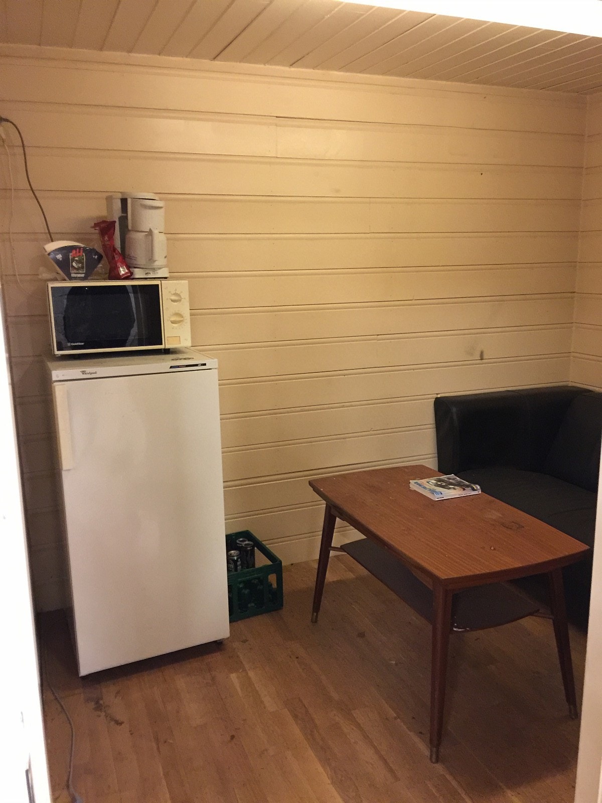 innvendig kontor innredet med kjøleskap,micro ovn, panelovner, sofa og bord. Galleribilde