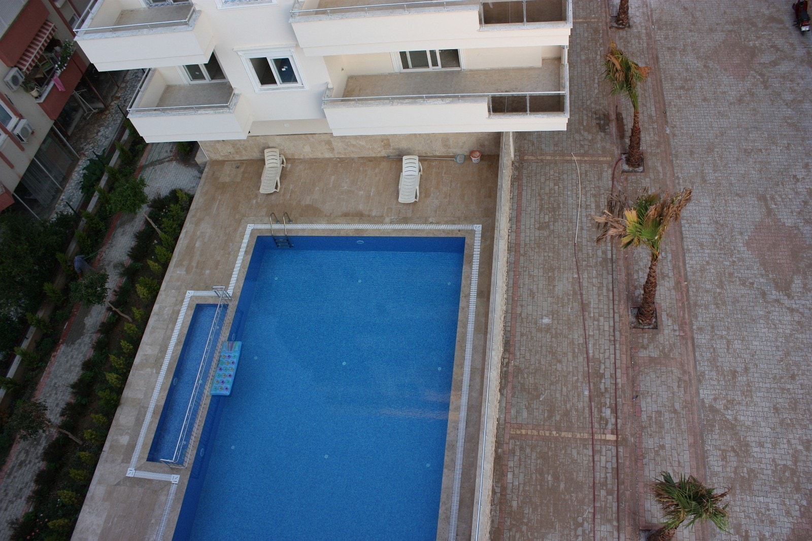 Basseng med lite barnebasseng som tilhører Alanya Beach Resort II. Bildet er tatt fra leilighetens private takterrasse. Galleribilde