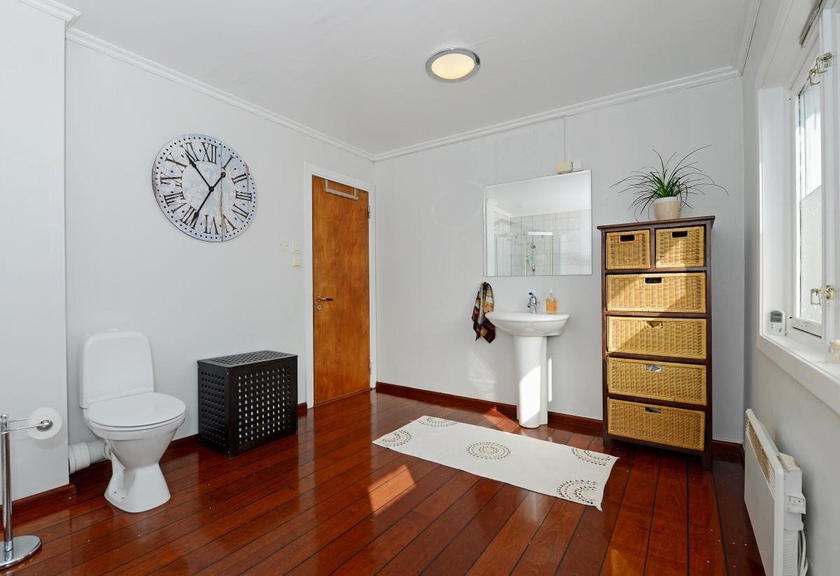 Gulvet på badet er lagt med heltre merbau som skipsgulv og det er fliser i dusjsonen. I gulvet under flisene er det varmekabler. Galleribilde