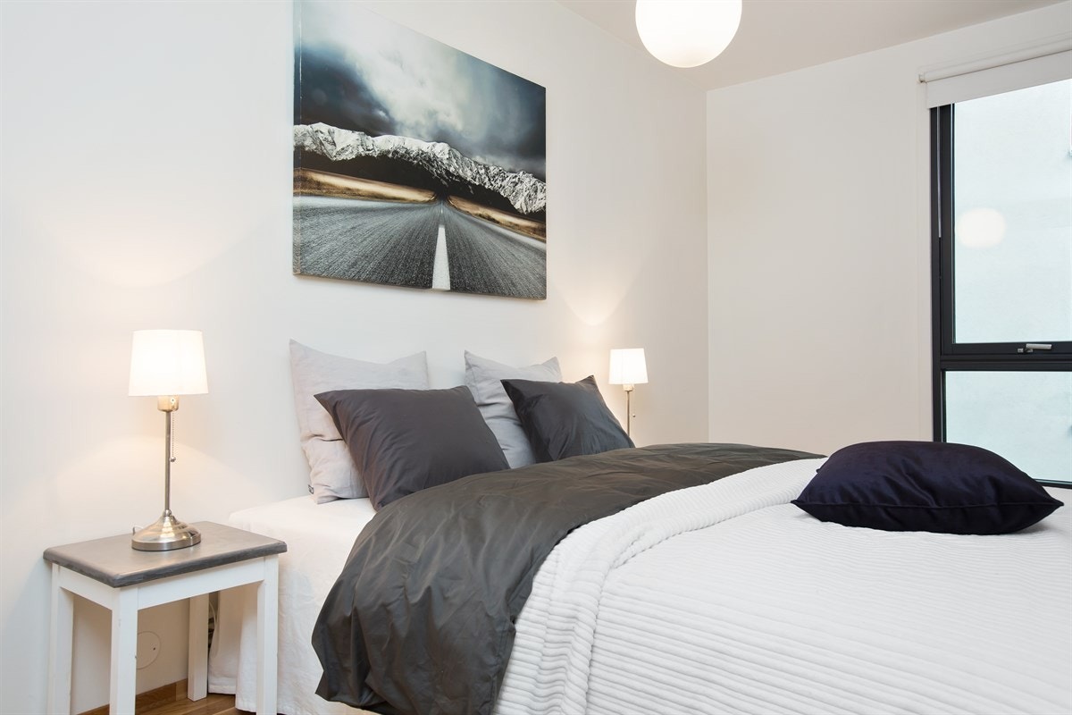 Det er plass til en stor dobbeltseng, tilhørende nattbord og ulike skap-/hylleløsninger. Galleribilde