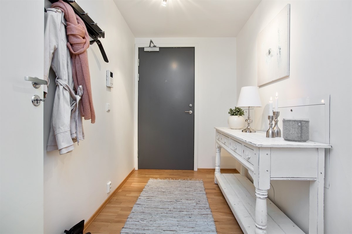 Man kan selv velge å sette opp hyllesystemer langs veggen, eller benytte den innvendige boden videre inn i entréen. Der er mer enn nok plass. Galleribilde