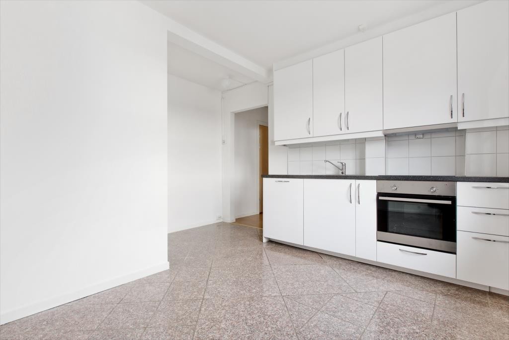 Lekkert, nytt kjøkken med skapfronter i hvit høyglans og integrerte hvitevarer. Galleribilde