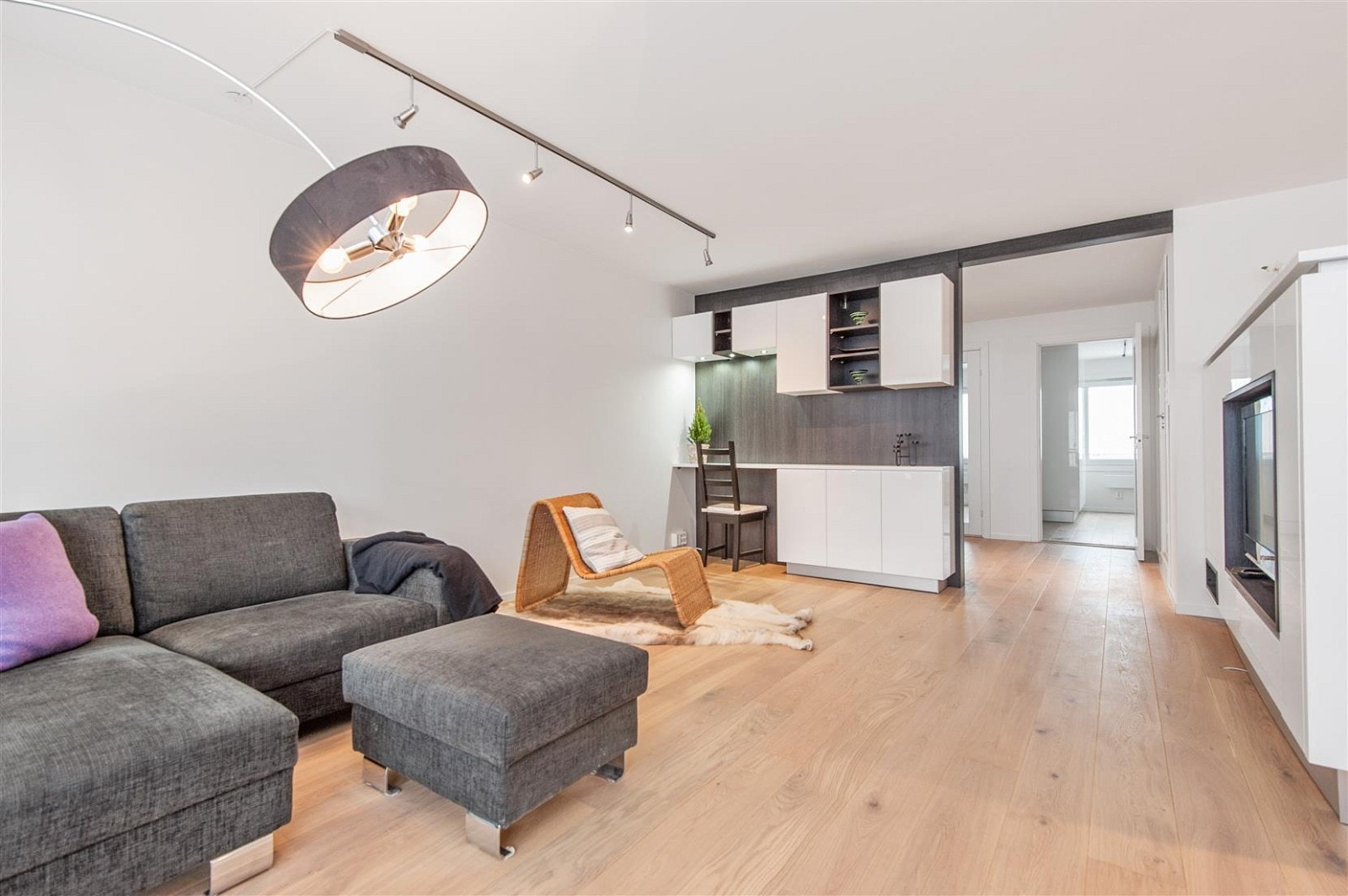 Det er praktisk halv delevegg mellom stue og kjøkken med integrert skapløsning og plass til flatskjerm TV. Galleribilde